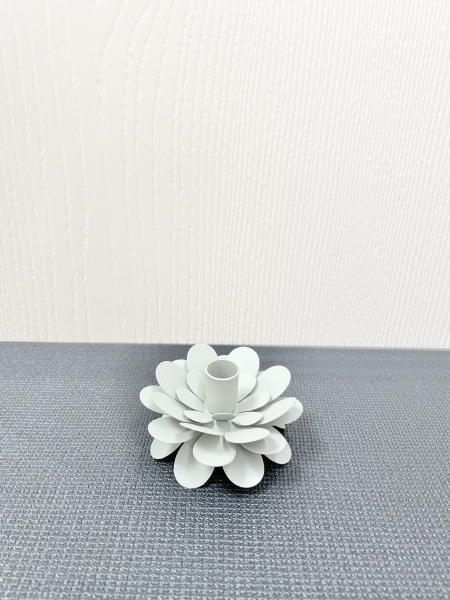 Zu sehen ist ein Kerzenhalter aus Metall in Form einer Blume für Stabkerzen